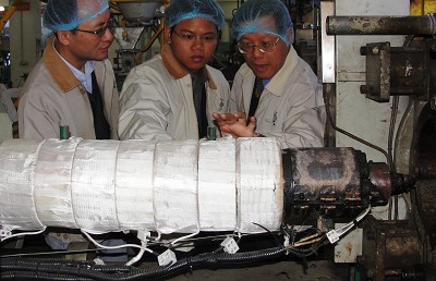 A close-look for three men checking a machine